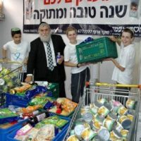 יו"ר חסדי נעמי הרב יוסף כהן עם מתנדבים אורזים סלים לראש השנה